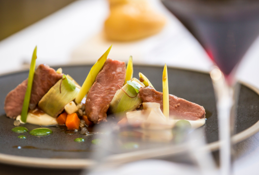 Close up of a pork and root vegetables dish with red wine