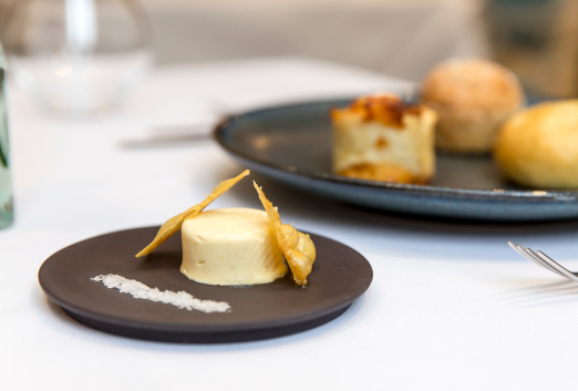 Close up of chicken skin and butter on a small gray stone plate