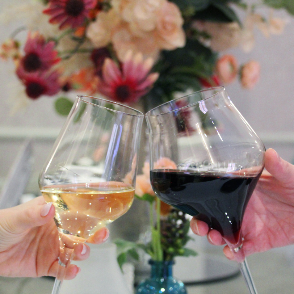 Two wine glasses clinking together over dinner
