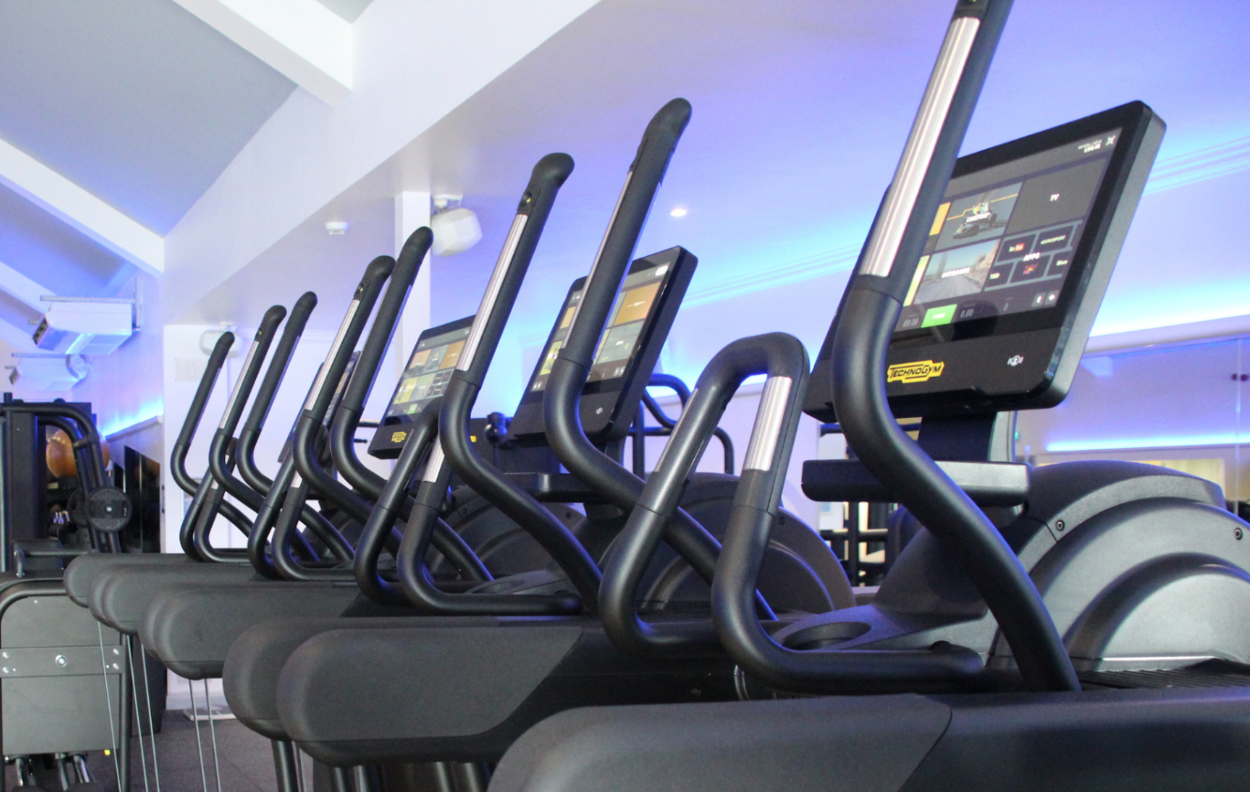 Row of step technogym cardio machines