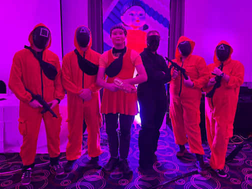 Characters from the show Squid Games standing in a purple room