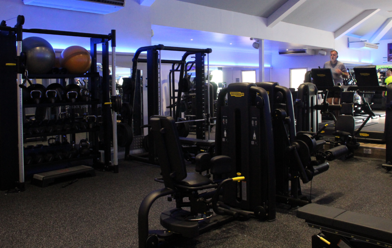 The Leisure Club technogym with resistance machines, barbell rack, and cable machines on display