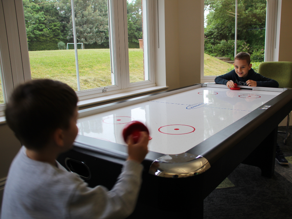 Two kids playing air hockey