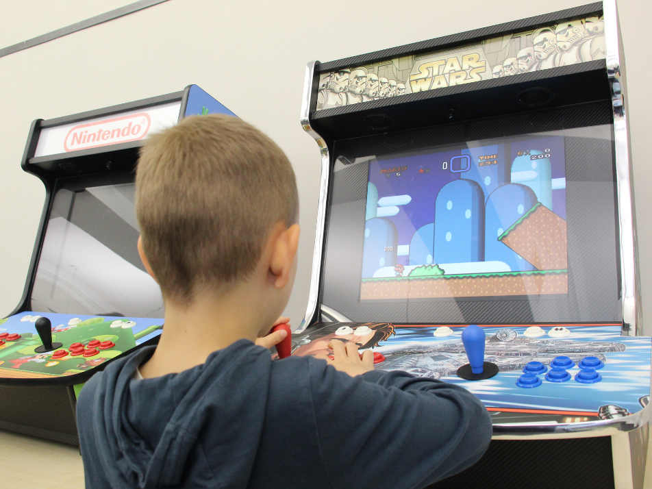 A child playing on a super mario bros arcade machine