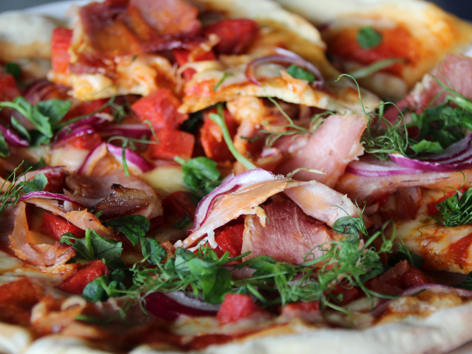 Up close photo of a tomato and cheese pizza