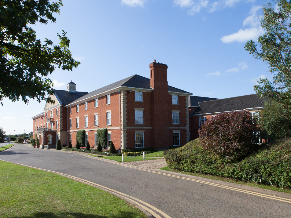 An exterior of the front of Whittlebury Hall Hotel on a sunny day