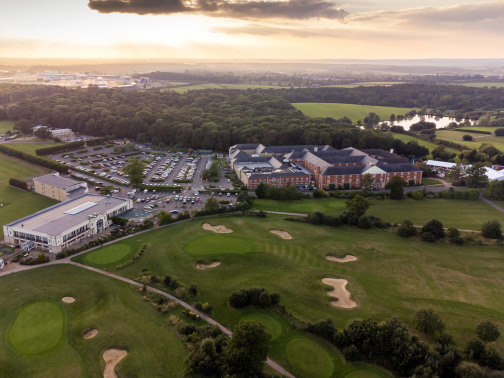A birds eye view of the Whittlebury Park estate and golf course with the sun setting in the background