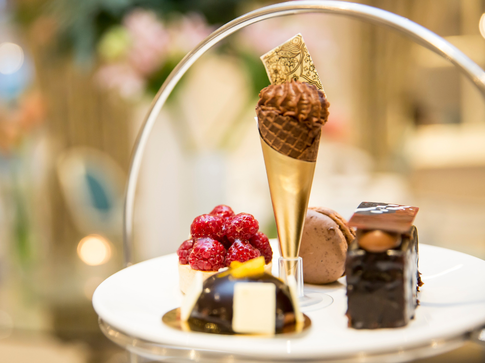 A chocolate themed afternoon tea sweet place with a brownie, chocolate tart, and chocolate cone