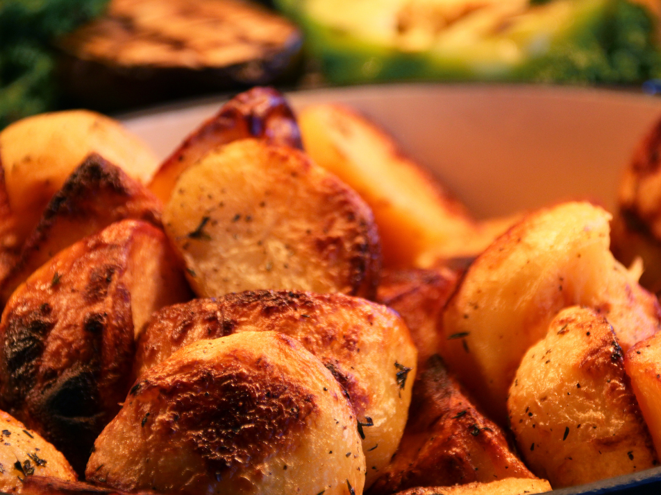 A stack of crispy roasted potatoes with thyme seasoning