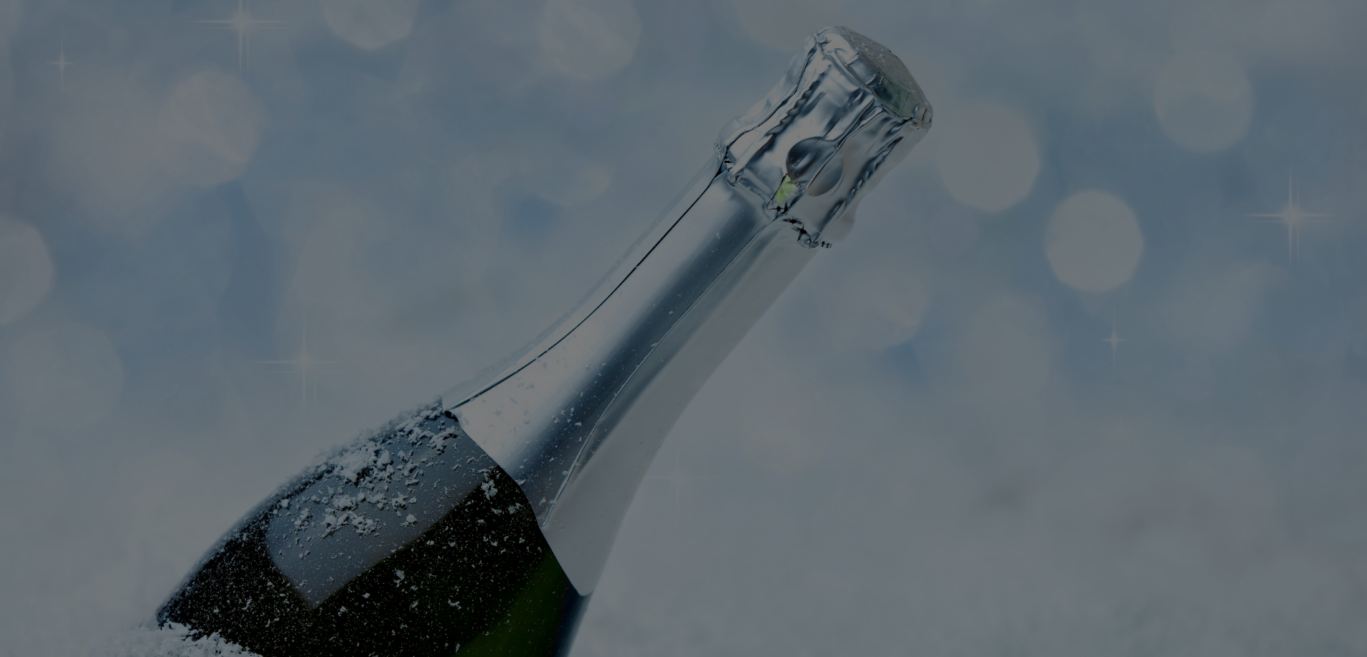 A corked bottle of champagne sitting on top of a bed of snow