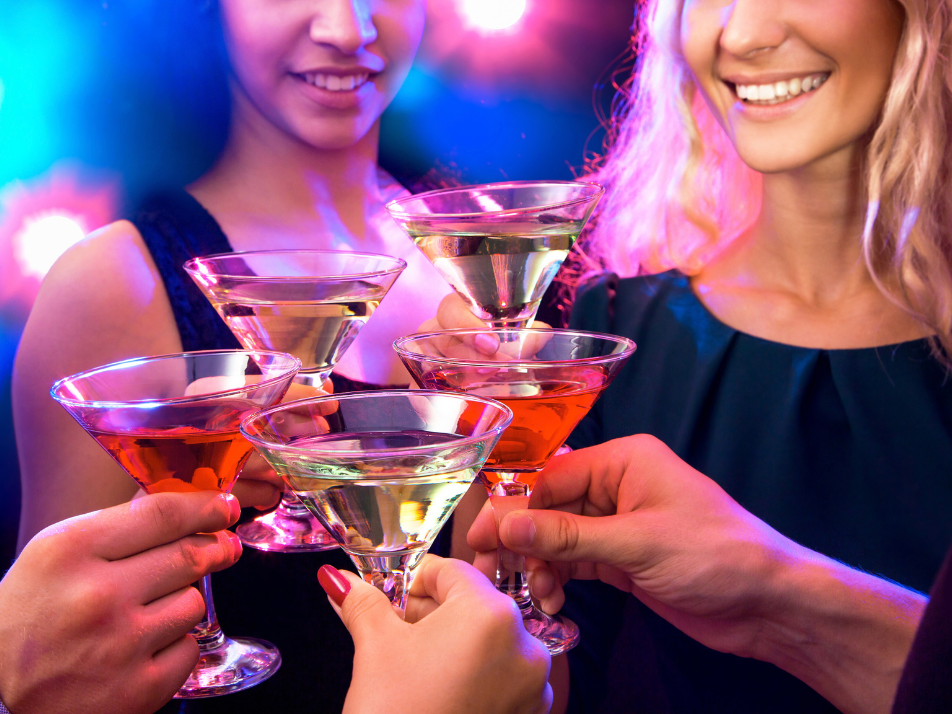 Group of girls clinking cocktail glasses together